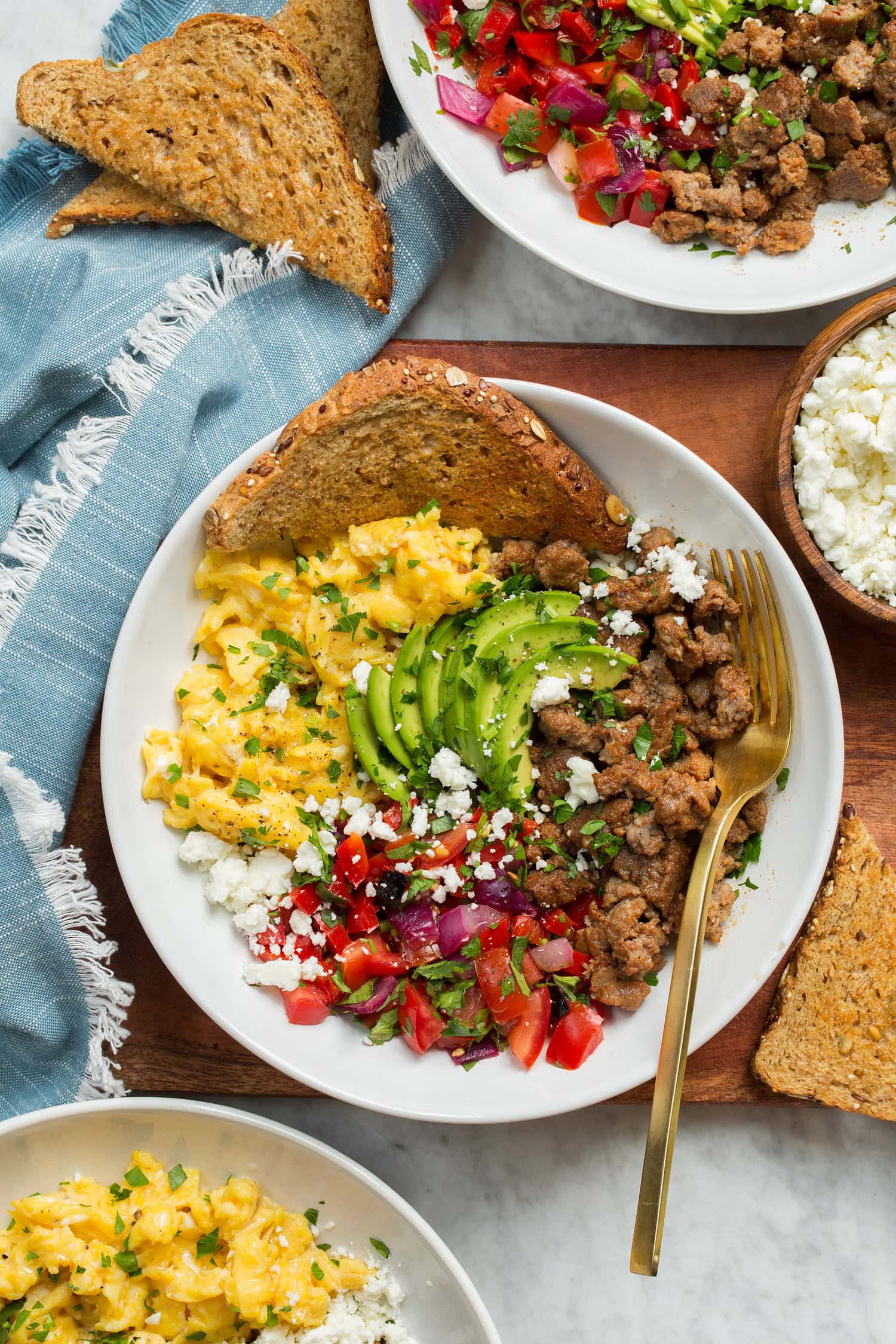 Breakfast Bowls Overhead photo of breakfast bowl on a wooden tray with a blue cloth to the side.