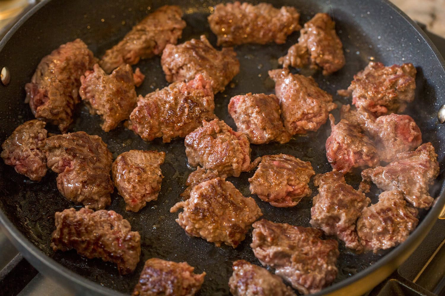 Burger Bowls Beef chunks in skillet turned to show golden brown side.