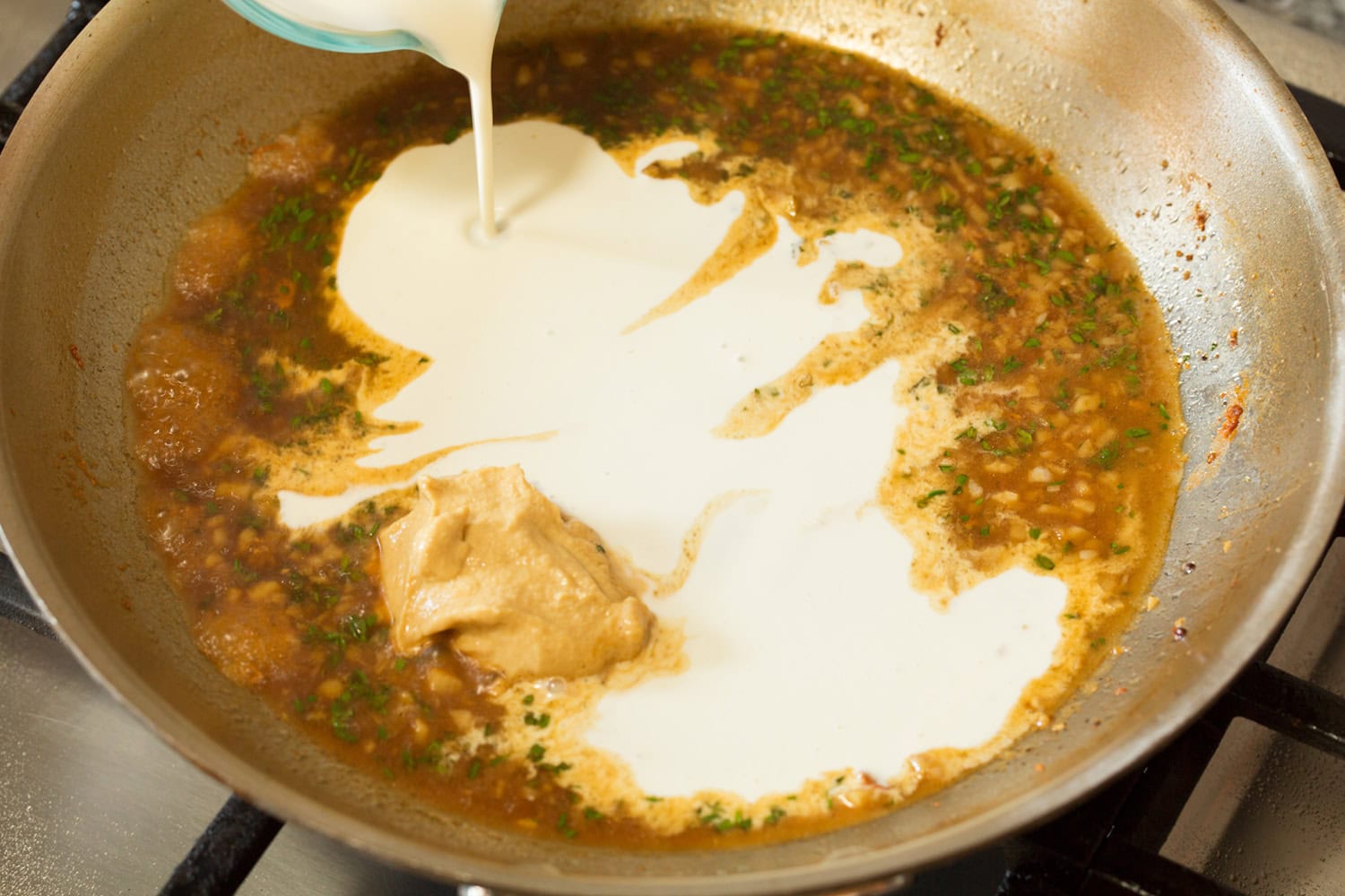 Creamy Dijon Mustard Chicken Heavy cream added to broth mixture in skillet.