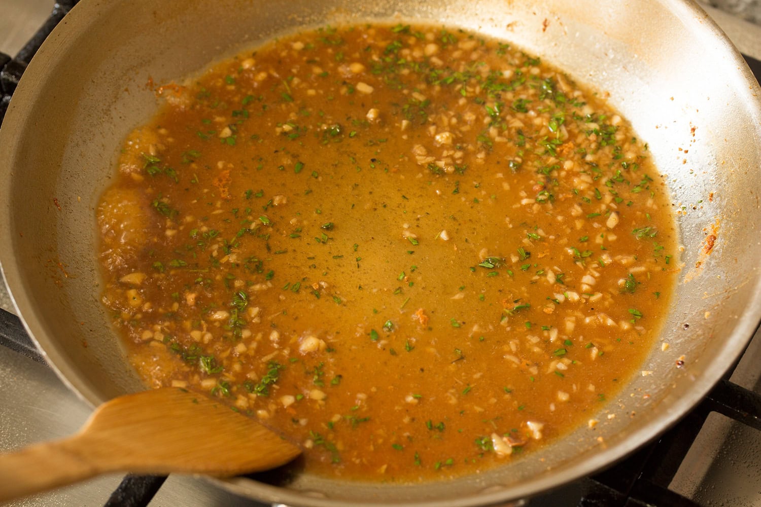 Creamy Dijon Mustard Chicken Chicken broth and herbs added to sauteed garlic in skillet.