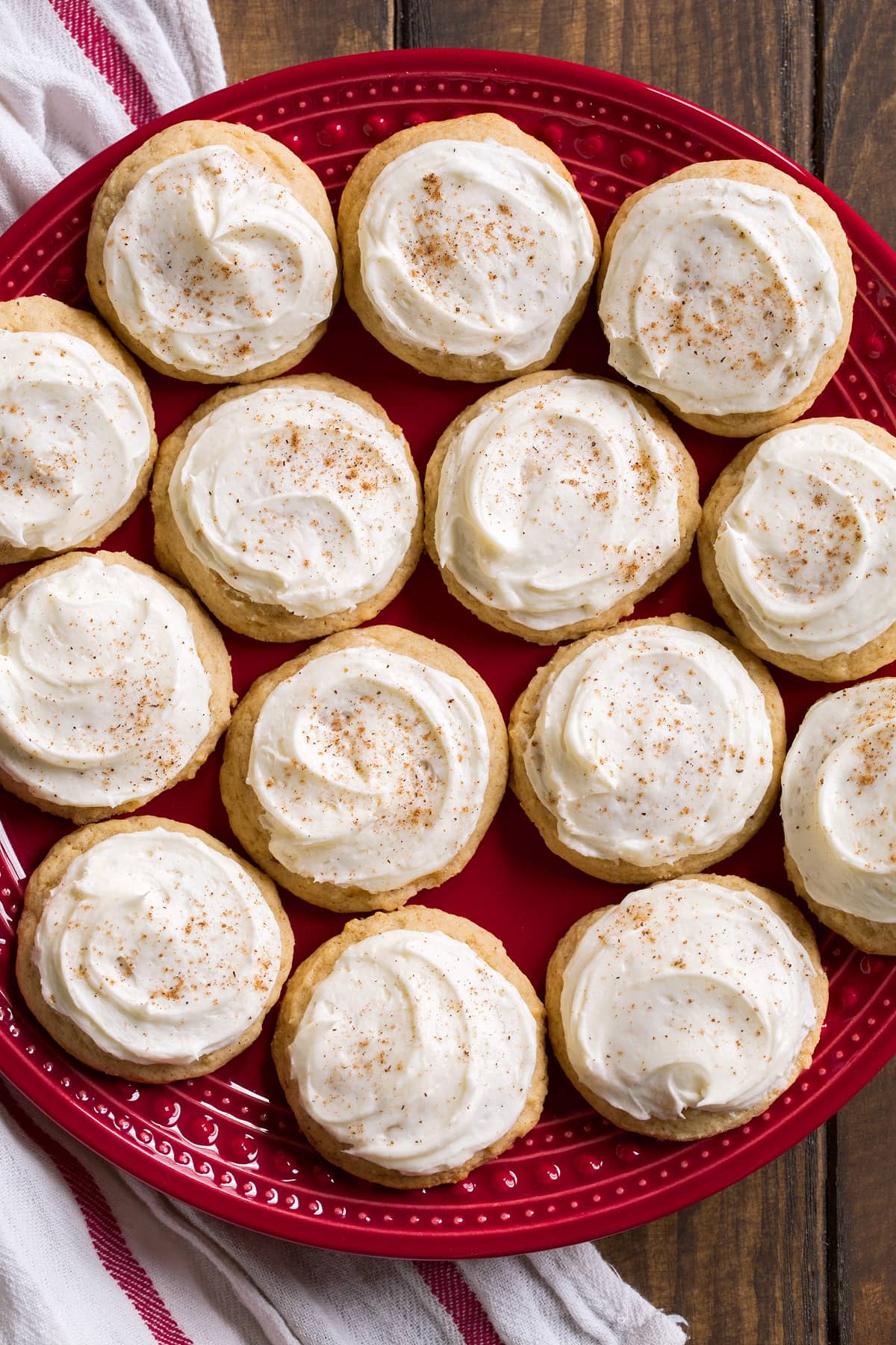 Eggnog Cookies Red plate full of 14 frosted eggnog cookies.