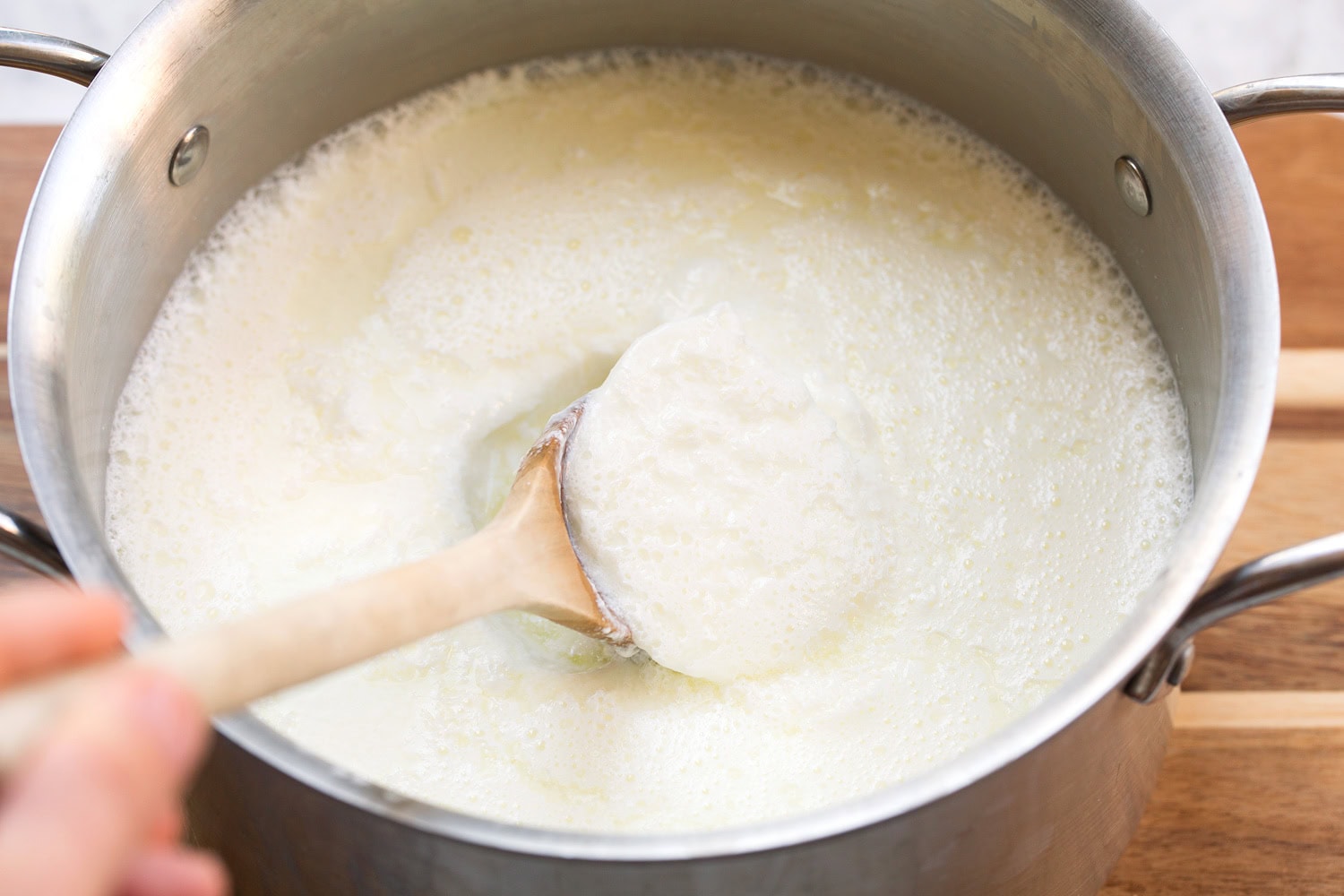 Homemade Yogurt Yogurt shown after setting overnight with a spoon scooping some out.