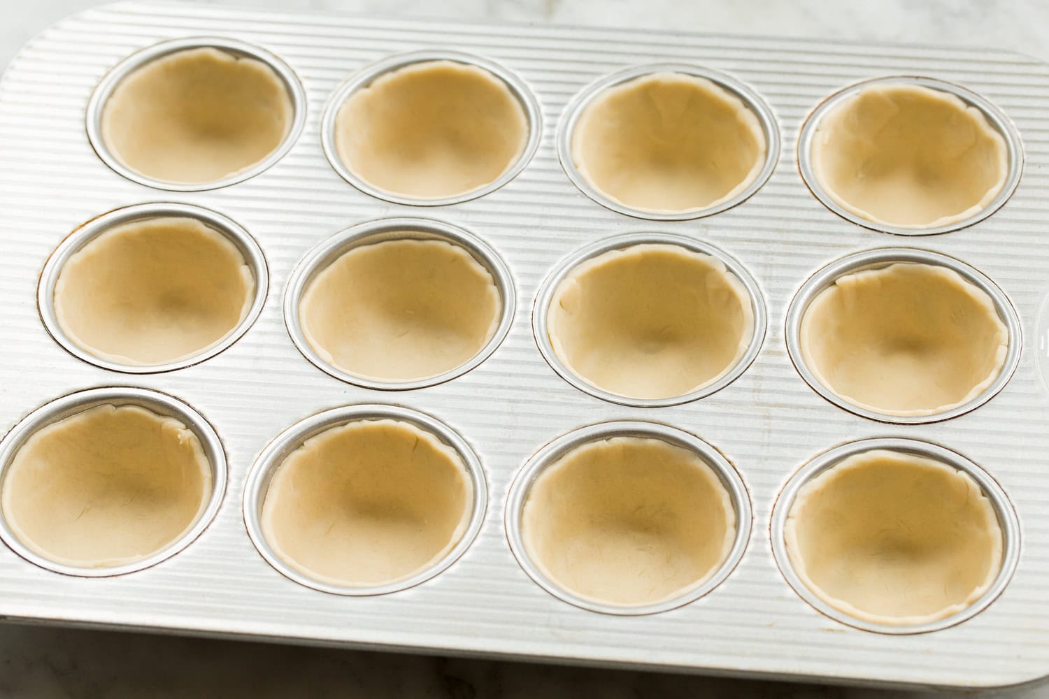 Mini Quiche Pie crusts in muffin tin.