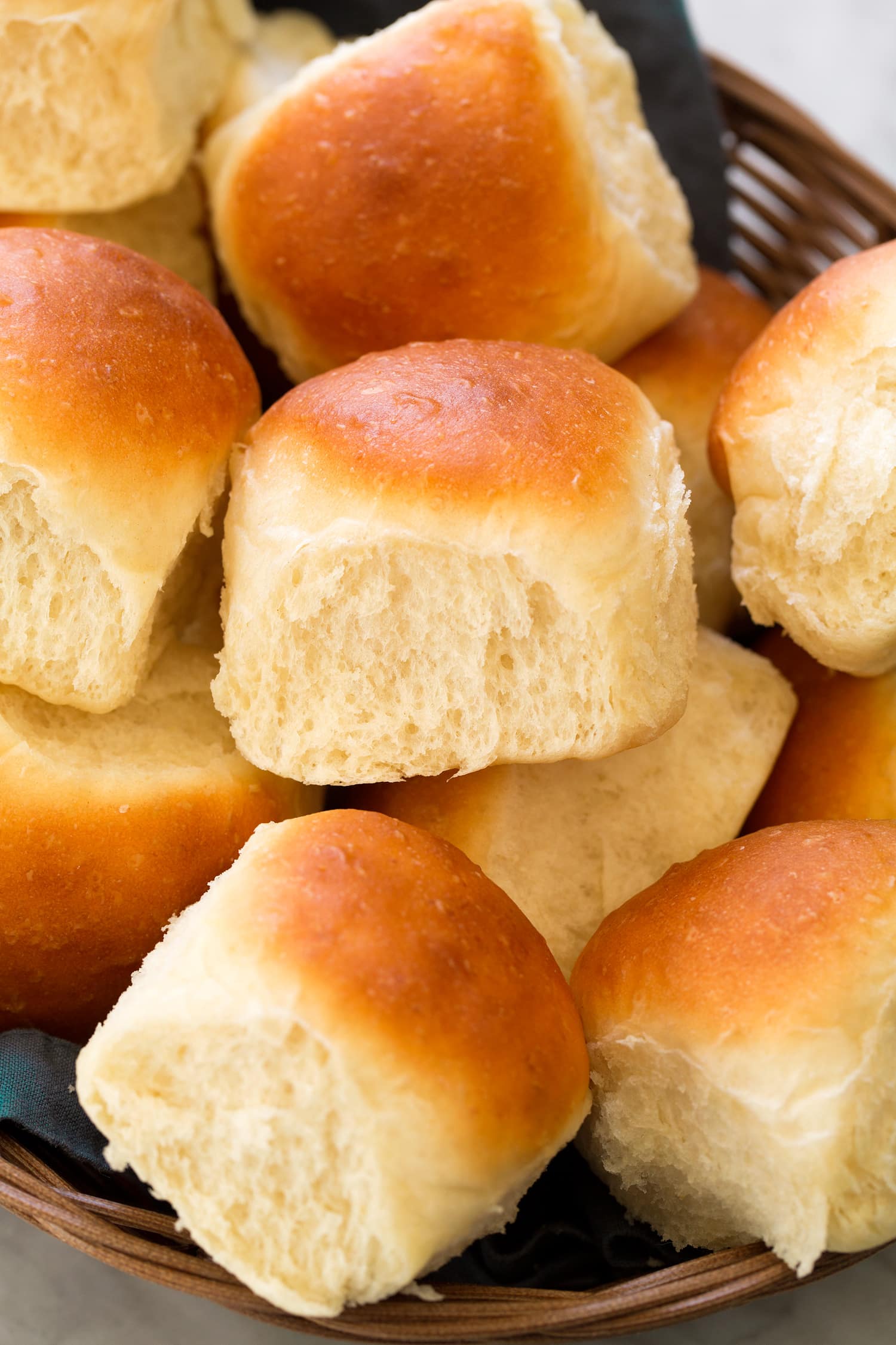 One Hour Dinner Rolls Close up photo of homemade dinner roll showing soft and fluffy texture and golden brown tops.
