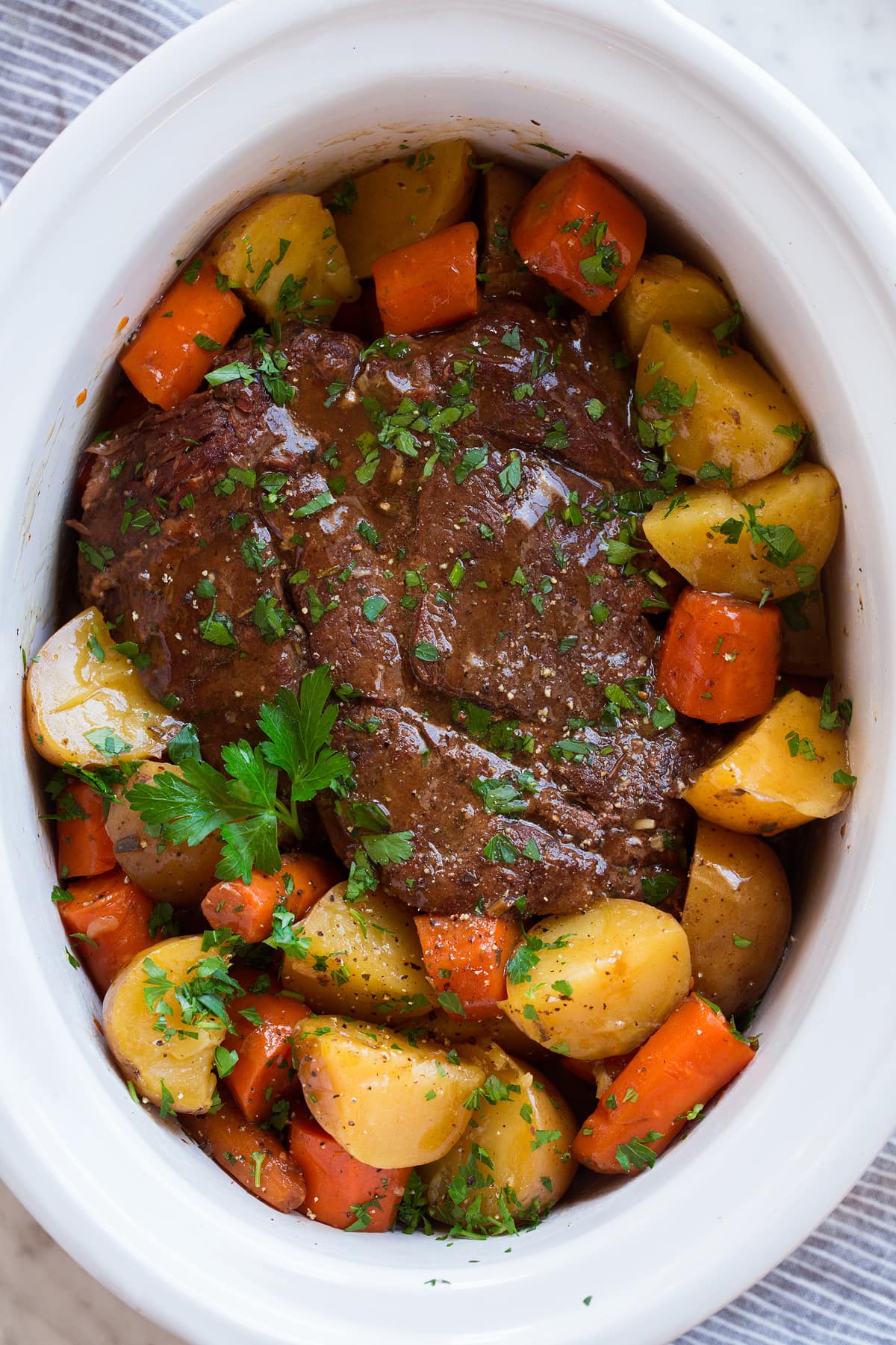 Best Ever Slow Cooker Pot Roast Slow cooker pot roast in a white crockpot