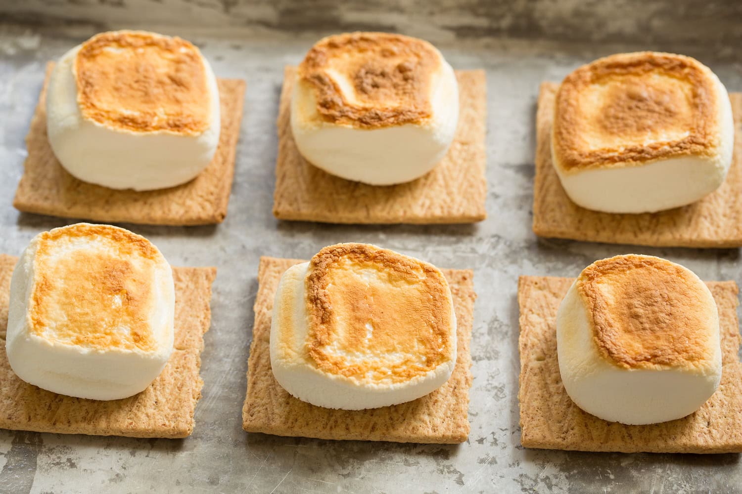 Oven S'mores Marshmallows on graham cracker shown toasted on second side.