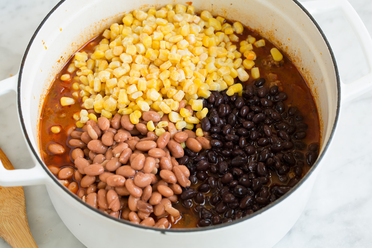 Taco Soup - easy, incredibly tasty soup! Loaded with hearty ingredients and brimming with delicious seasoned flavor. Perfect for cold fall and winter days! #tacosoup #soup #fall #recipe Adding beans and corn to taco soup.